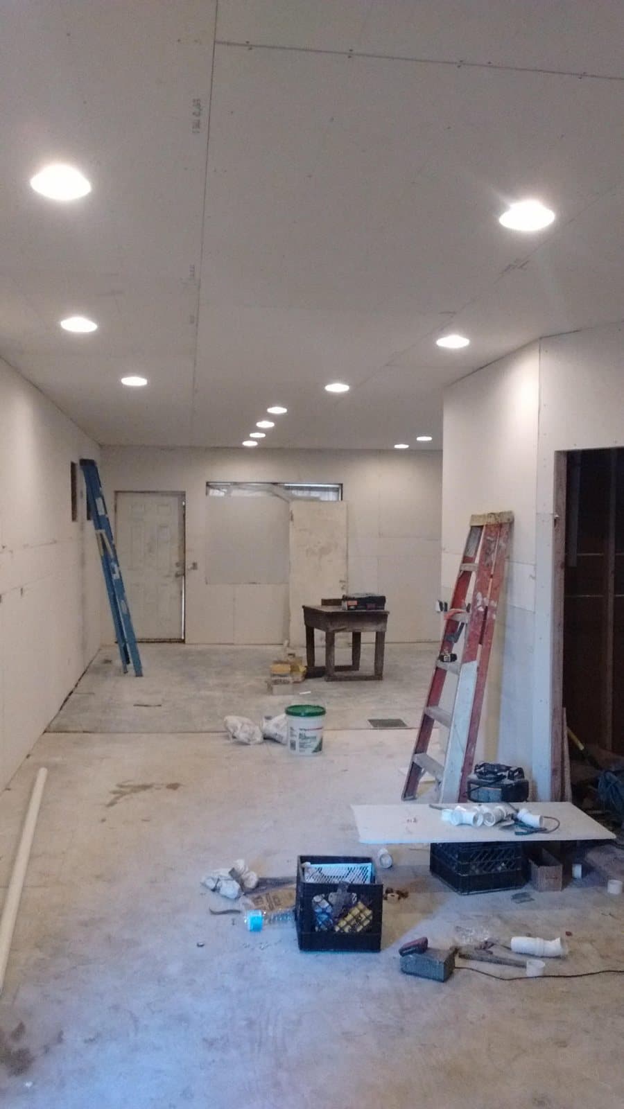 Habitación con tablaroca nueva en todos los muros y el techo y las luces empotradas ya cableadas y encendidas, antes del encintado y la pintura